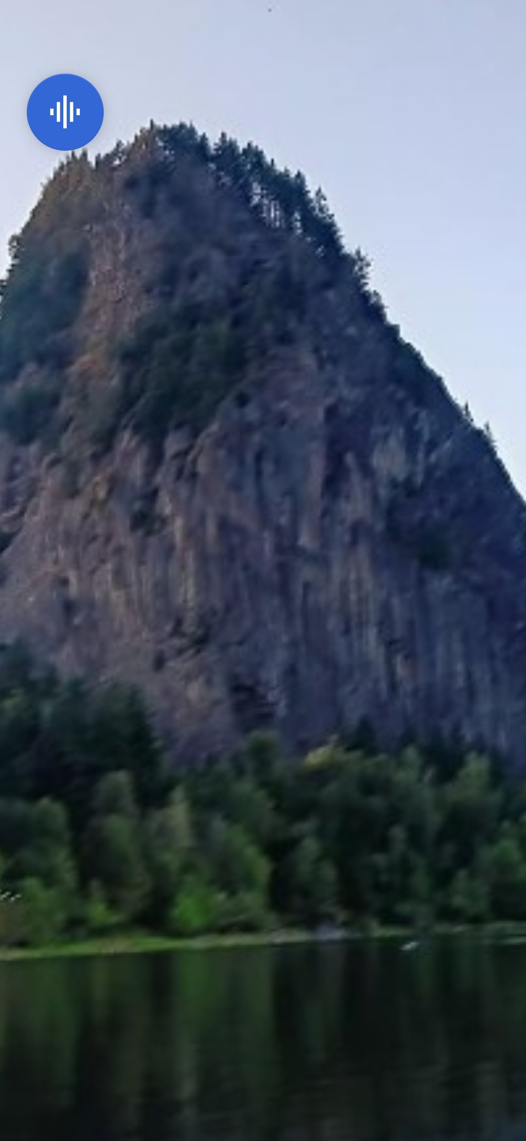 Zoom investigativo sobre la cara occidental de Beacon Rock por el Perceptor mostrando la estratificación columnar vertical del basalto con patrones de sombra más oscuros y retraídos comenzando a resolverse en geometría facial