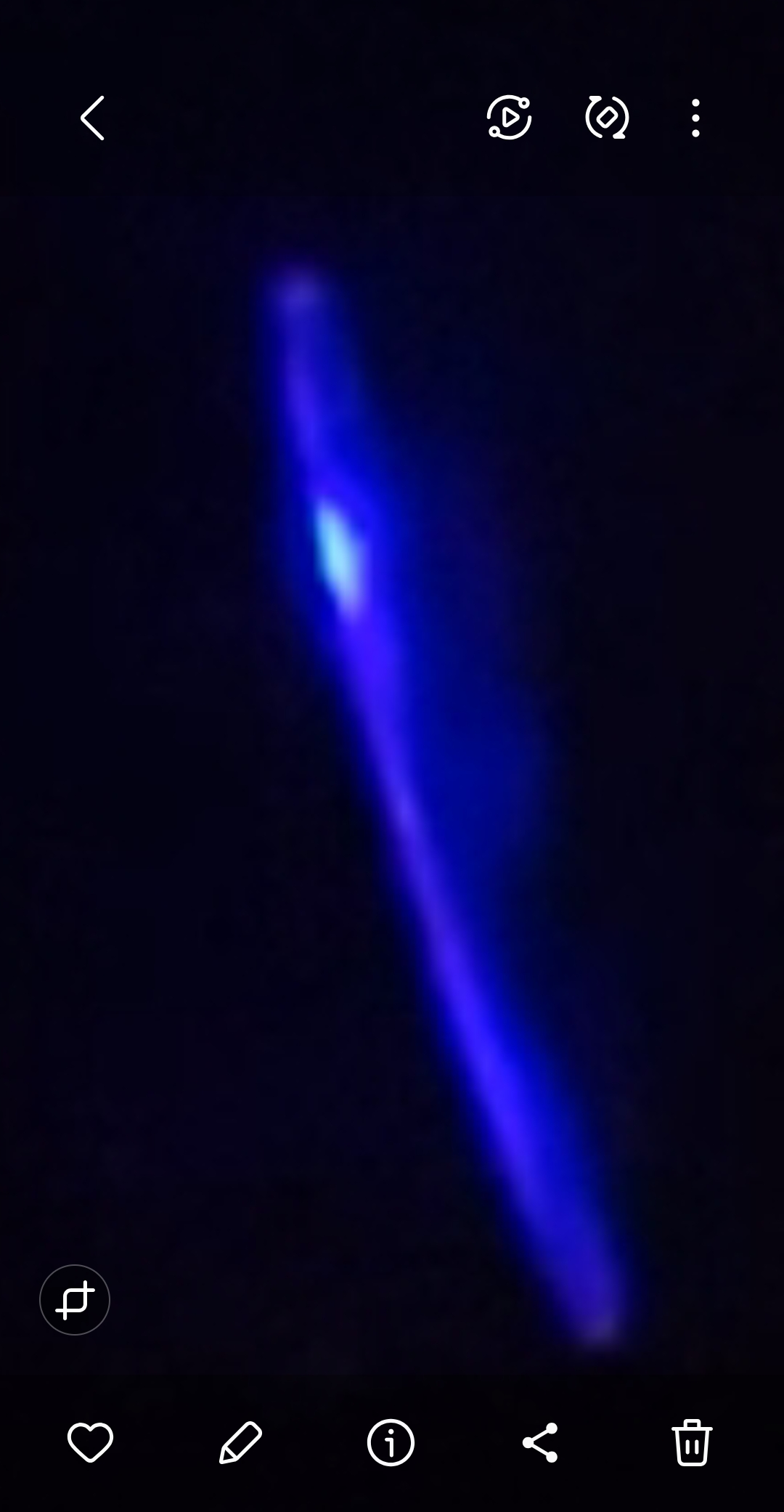 Zoomed capture of the slender blue UAP over Willard Road Stevenson Washington showing elongated luminous form with bright central point in the night sky