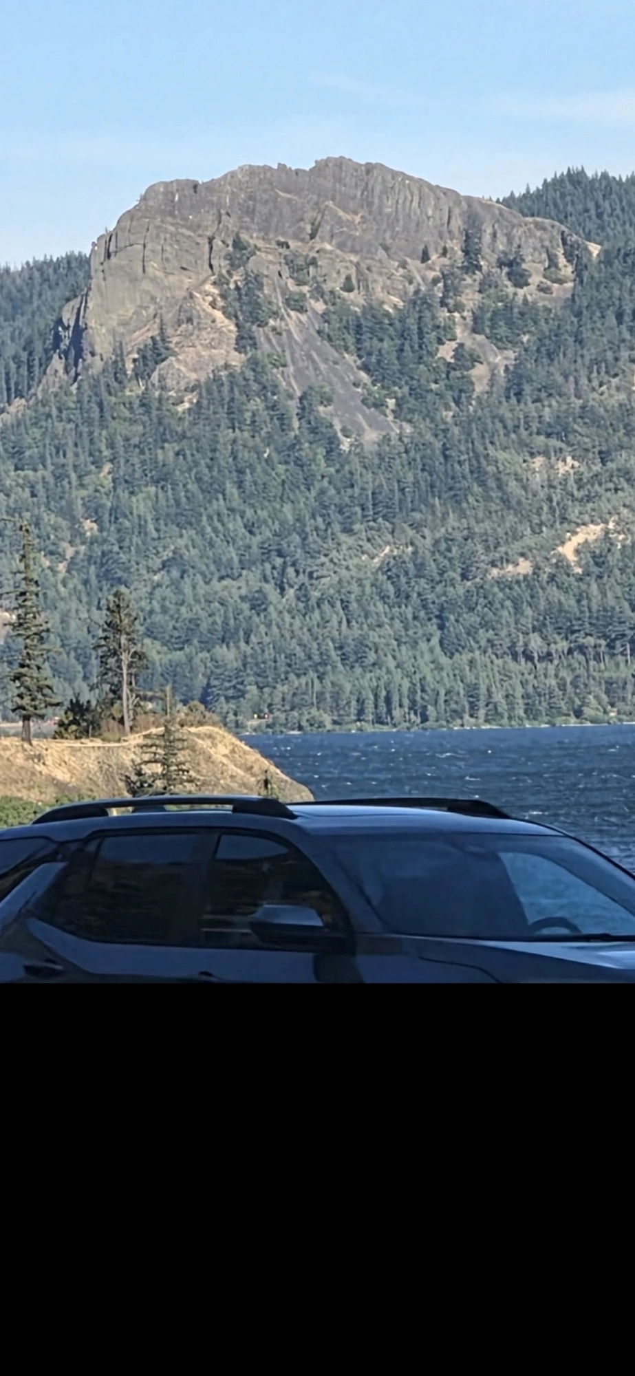 Deeper zoom onto the windshield of the passing vehicle - the driver's facial geometry begins to resolve as reptilian