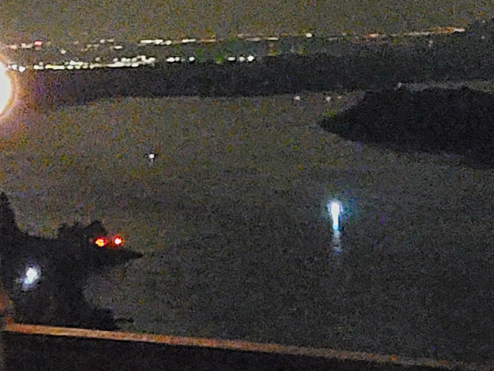 Establishing shot from Lookout Point Corbett Oregon overlooking the Columbia River at 3 AM showing the UAP Elemental as a small luminous blue-white figure floating on the dark river with parking barrier in foreground