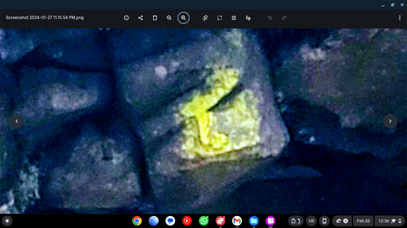 Yellow mossy watcher face entity visible at the center top section of the rock bridge interdimensional portal showing biological growth formation in the shape of a face