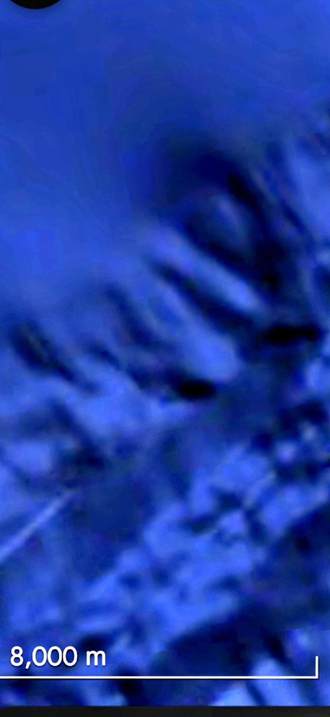 Wide context capture of a second underwater coordinate in the Mazatlán under-the-ocean Pacific Coast corridor rendered in deep blue with an 8000 meter scale bar visible at the bottom-left of the frame showing seafloor terrain that resolves into a different facial geometry from the first aquiferian face documented in this archive