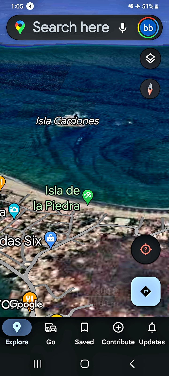 Vista aérea satelital más cercana de Isla Cardones en la Bahía de Mazatlán con Isla de la Piedra etiquetada al sur mostrando patrones curvilíneos de estela y perturbaciones de corriente visibles irradiando alrededor de la pequeña masa terrestre en el agua azul oscura del Pacífico especialmente prominentes en los lados oeste y sur documentando la macro firma de actividad sumergida sostenida bajo la superficie