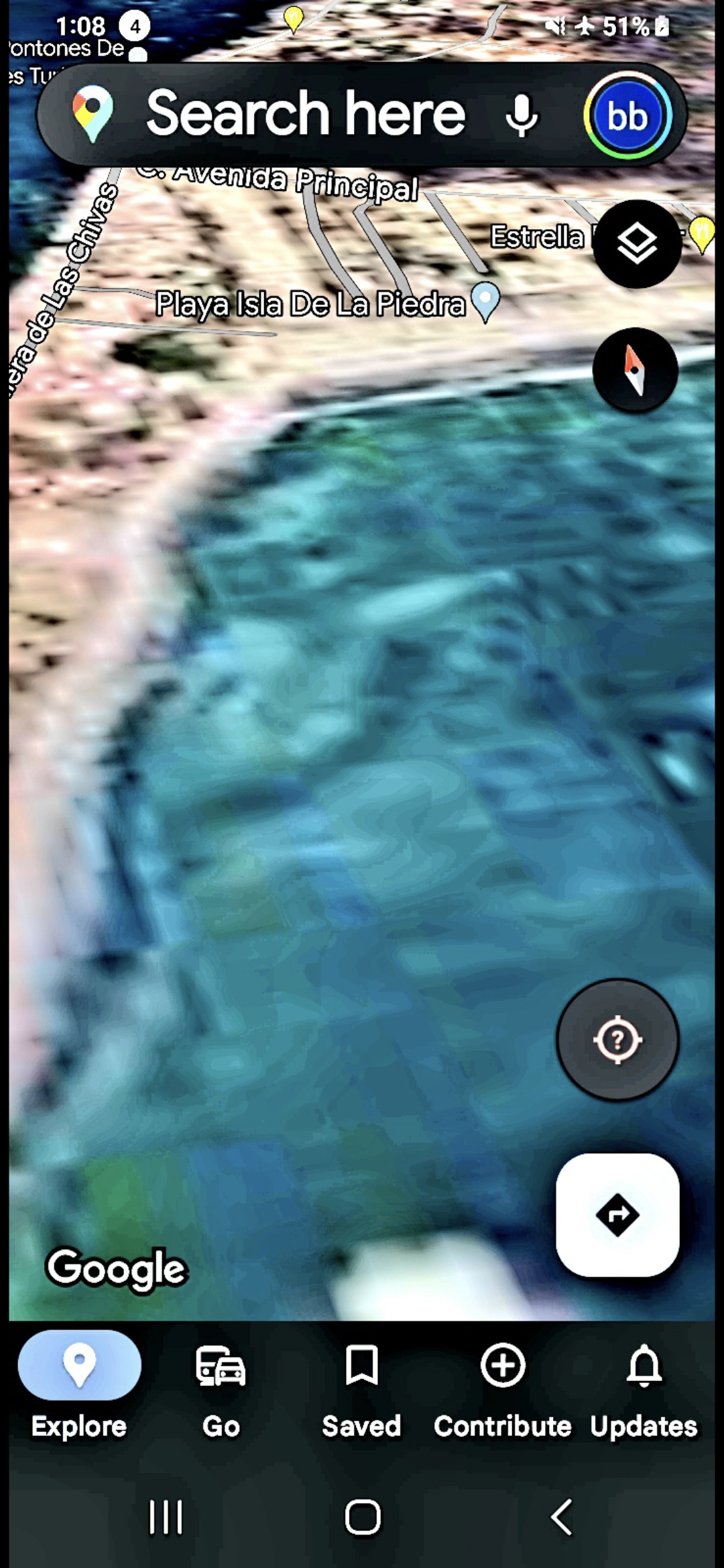 Satellite altitude approach over Playa Isla De La Piedra on the south side of Mazatlan Bay near the Estrella landmark showing shallow tropical turquoise water with a discrete non human form suspended just below the surface immediately offshore oriented upward toward the observer the entity that sensed the Perceiver's signal during the corridor scan and surfaced its position in response documenting the bidirectional surveillance pattern