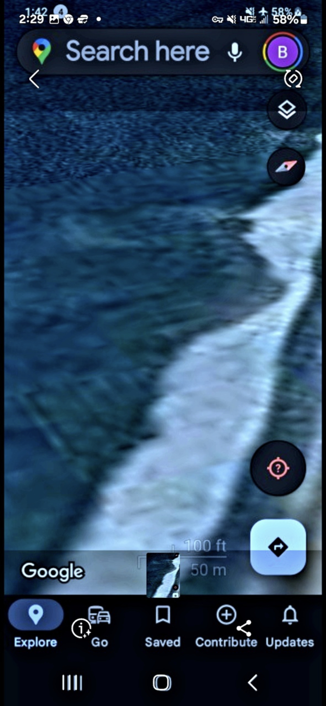 Tight zoom satellite capture at the wave break edge along the Stone Island south shoreline in Mazatlan Bay showing discrete geometric features visible beneath the white foam of the breaking surf documenting the close range view of the suspected reptilian base structure just below the wave break line