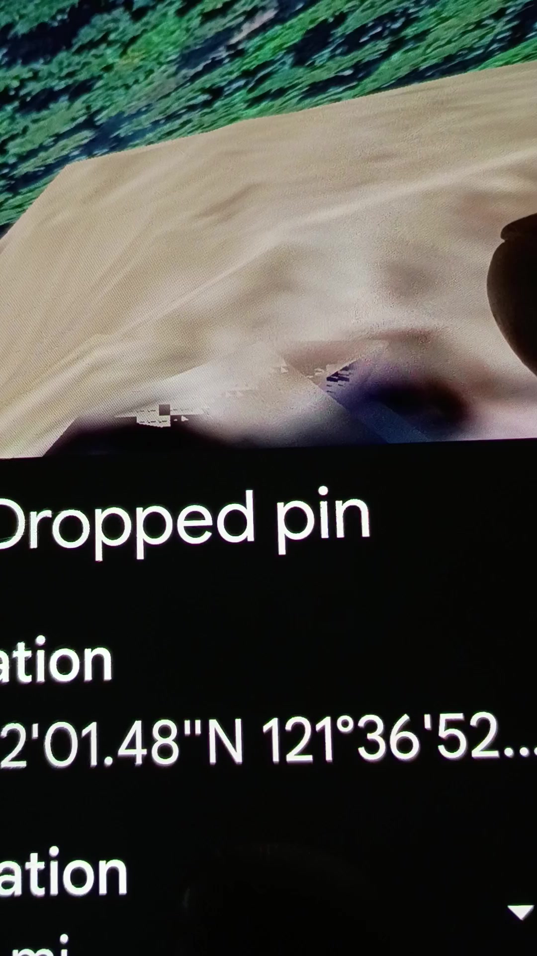 Smartphone screen recording frame from the Perceiver's Mitchell Point Google Earth capture showing a Dropped pin metadata overlay at the bottom of the screen with the geographic coordinates 45 degrees 42 minutes 01 seconds North 121 degrees 36 minutes 52 seconds West directly stamped into the recording as falsifiable verification of the documented coordinate