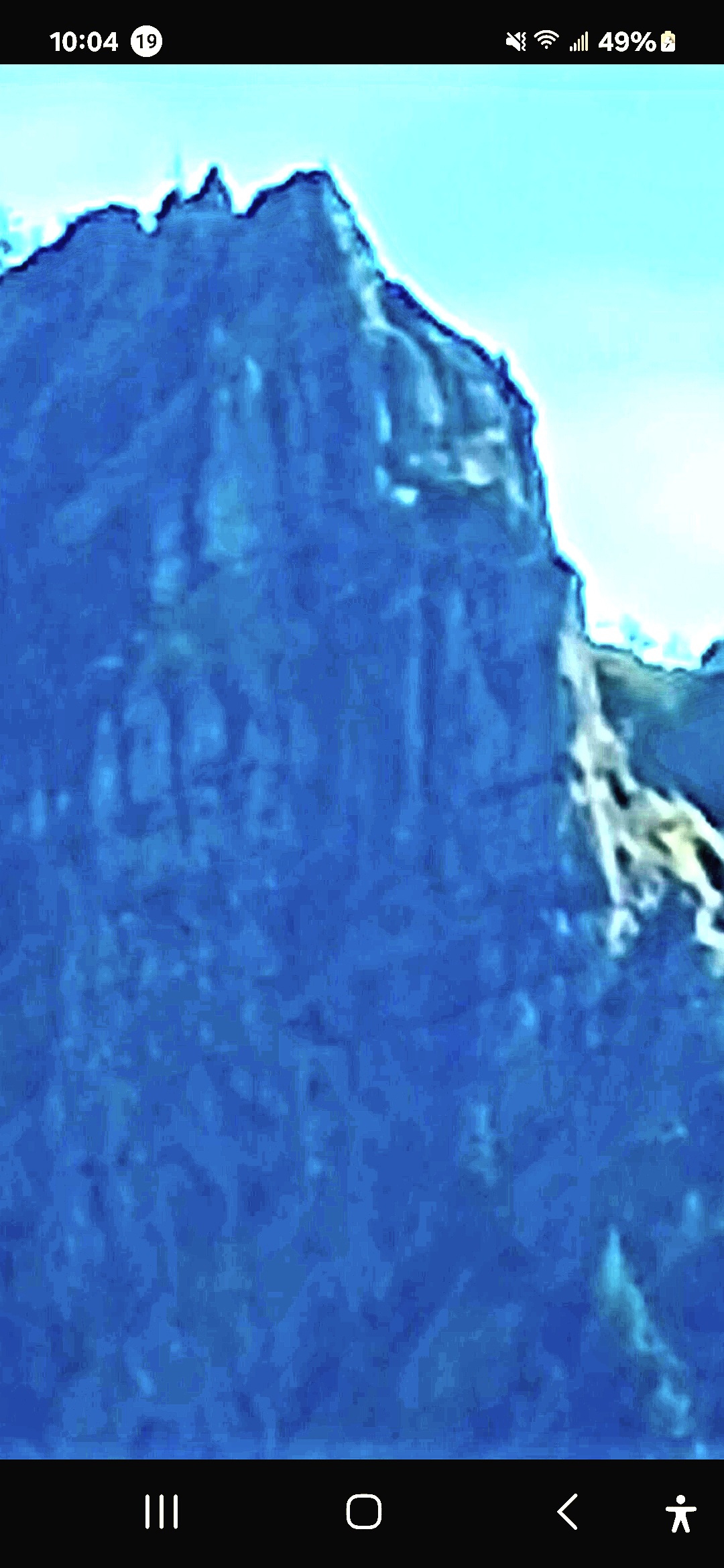Blue-filter infrared photograph of Mitchell Point Oregon showing the same basalt pinnacle from a different angle with deep blue saturated tones rendering the rock structure with surface detail and a face geometry visible at a different rotation than the daylight capture