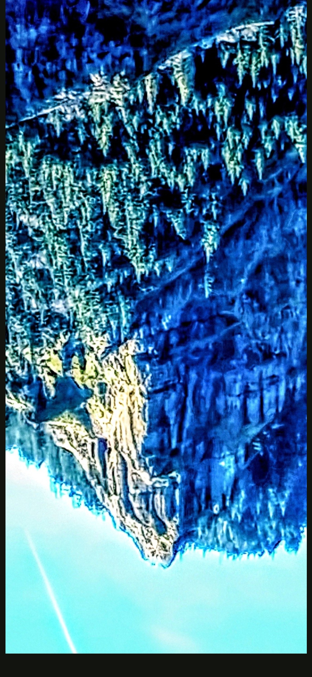 Same Mitchell Point Oregon formation rotated 180 degrees upside down with blue saturation filter revealing what the Perceiver reads as the REAL face of Mitchell Point an evil alien physiognomy with predatory facial geometry that is invisible in the conventional right-side-up orientation and only resolves through image inversion