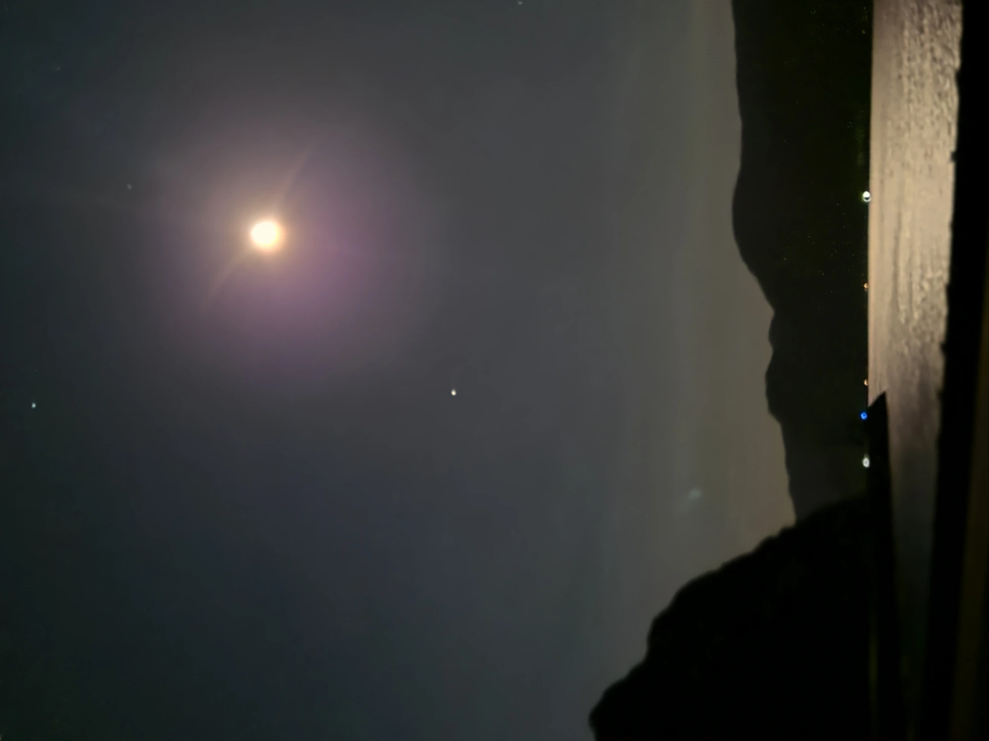 Wide-angle photograph of the moon over the Columbia River Gorge on the same night with a bright pinpoint star-like object visible in the mid-frame sky — the primary star-mimic candidate