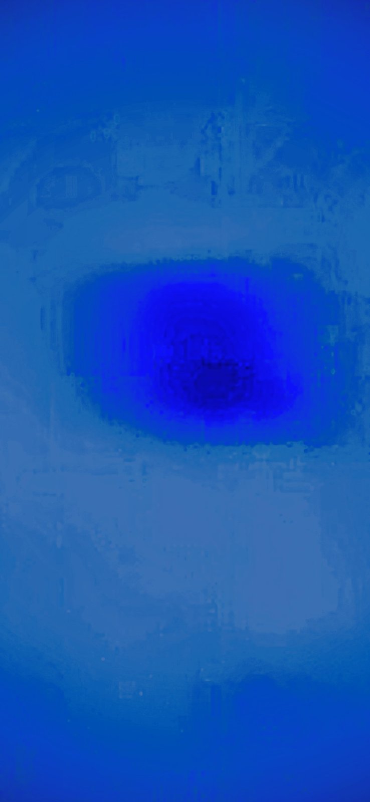 Macro close-up of a single dropped particle captured under different exposure conditions producing an intense royal-blue luminous halo around the dark mass core suggesting either reflective surface properties or active emission