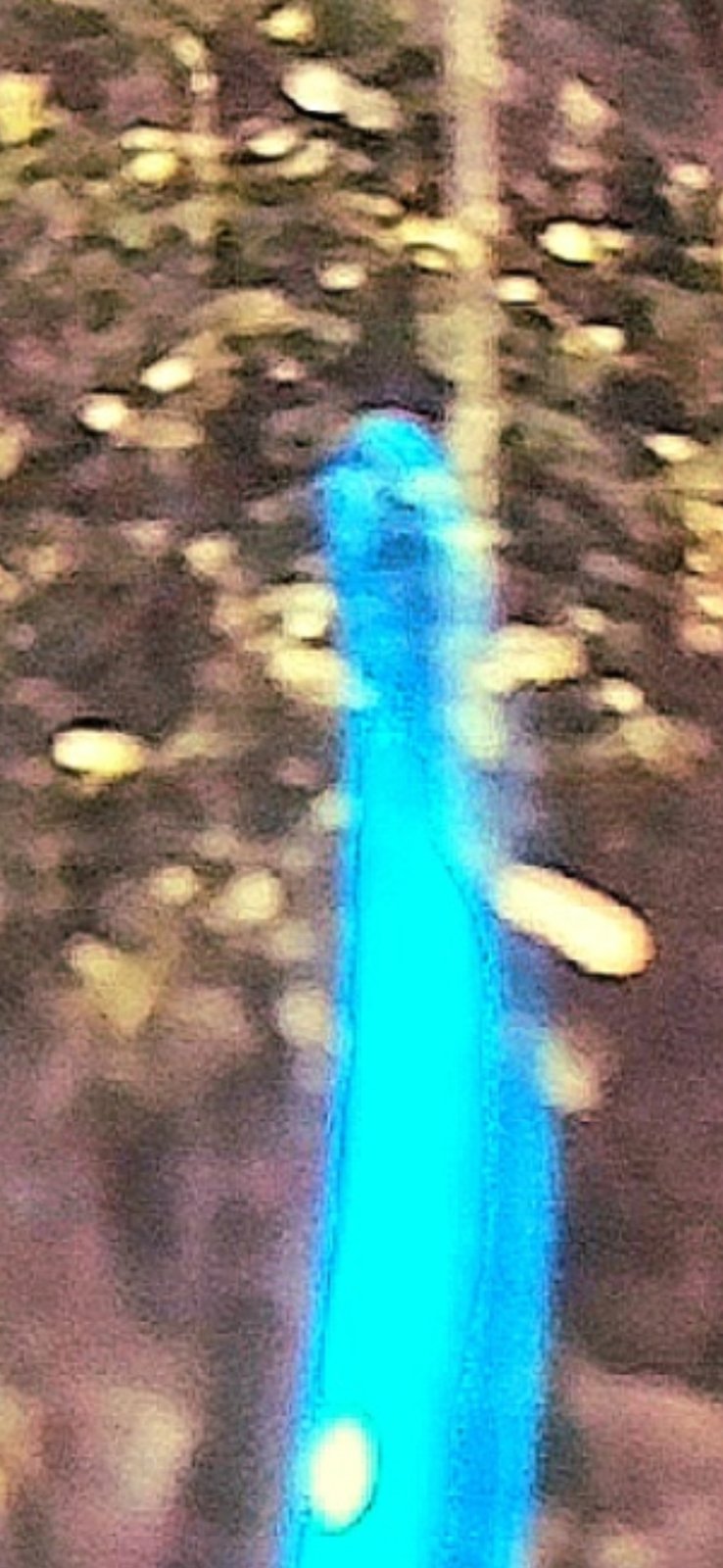 Bridge of the Gods Blue UAP shape-shift sequence frame two showing the head now more pronounced and visible arm-like extensions forming on either side of the upper body indicating the entity is actively shifting form into a humanoid configuration