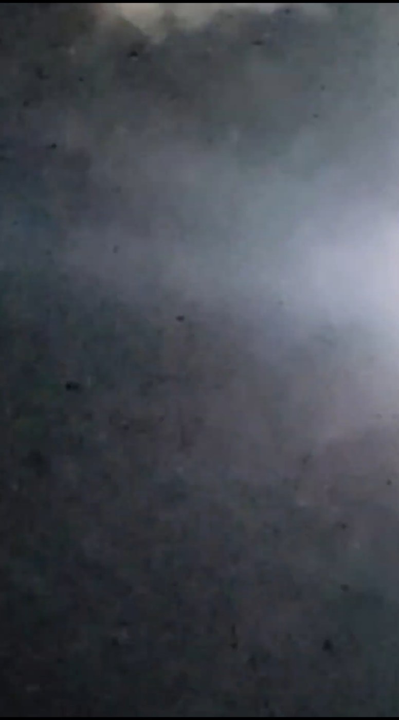Underwood Hill nighttime particle drop showing a single isolated dark discrete particle mid-descent against the luminous facial cloud at Highway 14 Columbia River Gorge